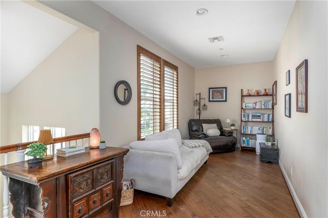 living area featuring visible vents, baseboards, and wood finished floors