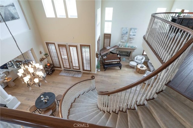 entryway featuring stairs, a high ceiling, baseboards, and wood finished floors