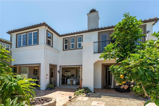 4027 W Hemlock St, Oxnard, CA 93035 - back of house featuring a balcony, stucco siding, a patio area, and a chimney