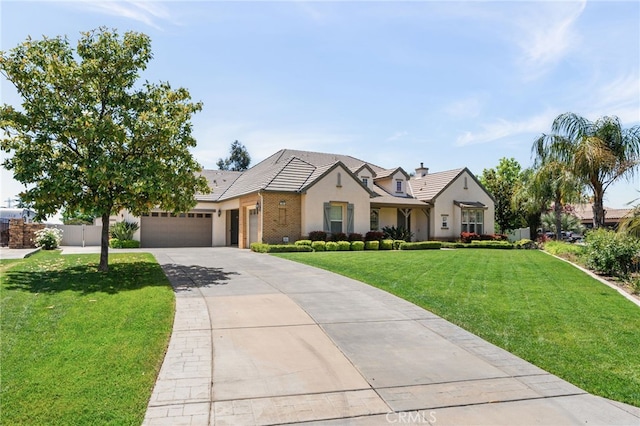 955 Union St, Cherry Valley, CA 92223 - view of front facade featuring an attached garage, driveway, a tile roof, stucco siding, and brick siding