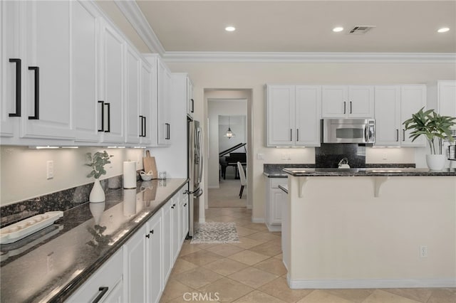 955 Union St, Cherry Valley, CA 92223 - kitchen featuring appliances with stainless steel finishes, a kitchen bar, white cabinetry, dark stone counters, and crown molding