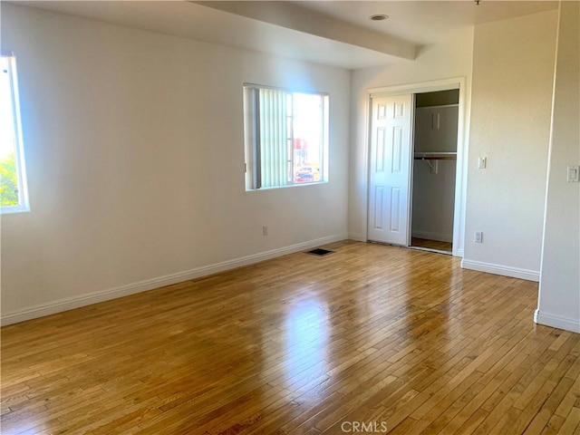 unfurnished bedroom with baseboards, a closet, and light wood-style floors