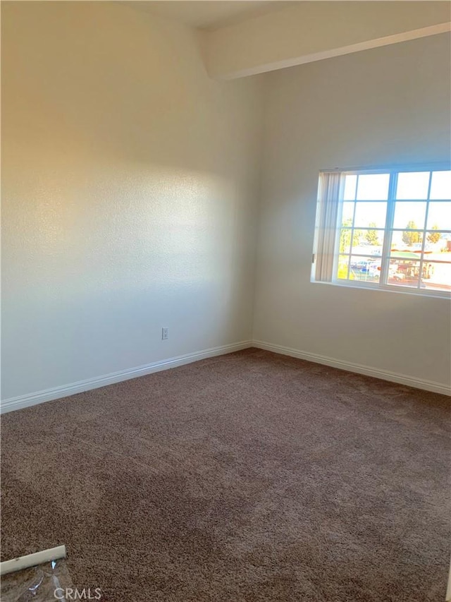 carpeted spare room with baseboards