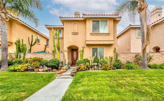 11175 Reagan St, Los Alamitos, CA 90720 - mediterranean / spanish-style home with a chimney, stucco siding, a tiled roof, and a front yard