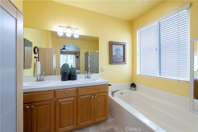 11175 Reagan St, Los Alamitos, CA 90720 - full bath with double vanity, a garden tub, a ceiling fan, a stall shower, and a sink