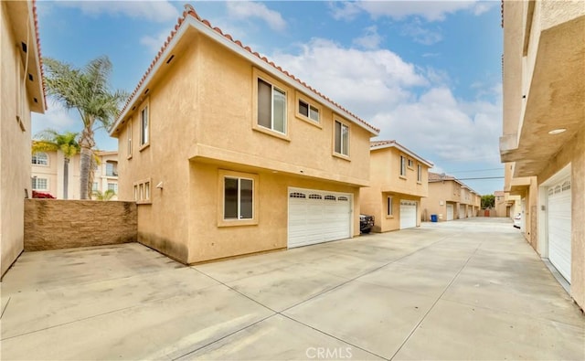 11175 Reagan St, Los Alamitos, CA 90720 - view of property exterior featuring a garage, stucco siding, concrete driveway, and a tile roof