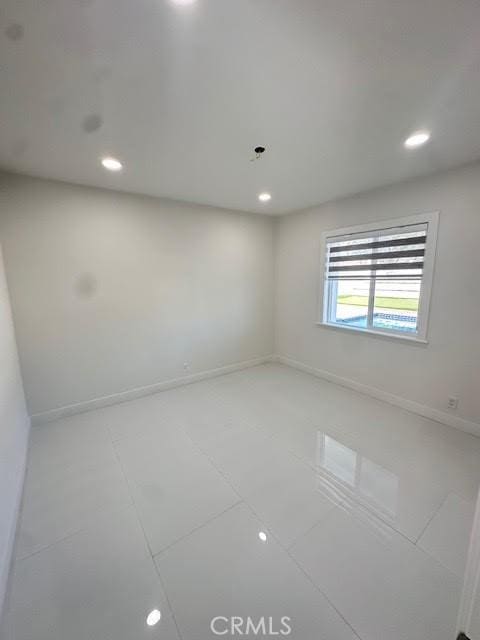 spare room featuring recessed lighting, baseboards, and tile patterned flooring