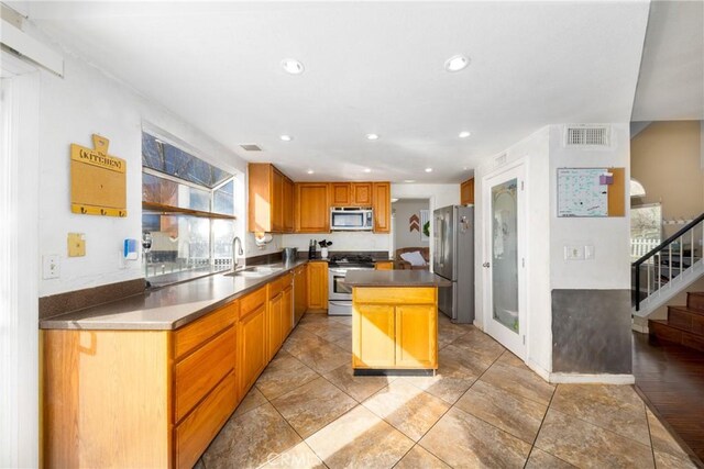 11874 Cornell Ln, Yucaipa, CA 92399 - kitchen with appliances with stainless steel finishes, a sink, a center island, recessed lighting, and dark countertops