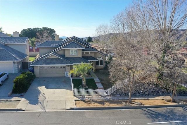 11874 Cornell Ln, Yucaipa, CA 92399 - view of front of home featuring stucco siding, a chimney, a fenced front yard, a mountain view, and driveway