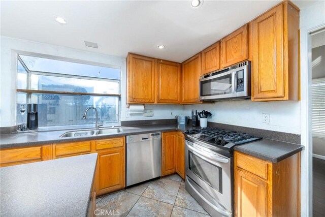 11874 Cornell Ln, Yucaipa, CA 92399 - kitchen featuring stainless steel appliances, a sink, dark countertops, brown cabinets, and recessed lighting
