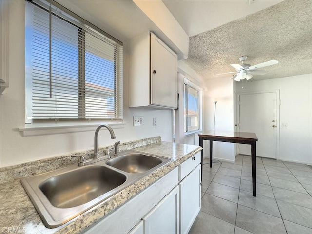 3501 20th St, Highland, CA 92346 - kitchen with a ceiling fan, light tile patterned flooring, light countertops, white cabinetry, and a sink