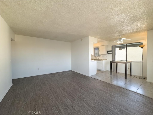3501 20th St, Highland, CA 92346 - unfurnished living room with a textured ceiling, baseboards, wood finished floors, and a ceiling fan