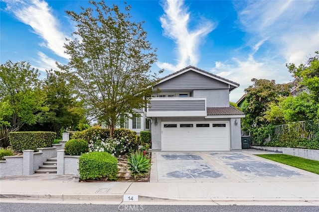 traditional-style home featuring fence, an attached garage, a tile roof, stucco siding, and concrete driveway
