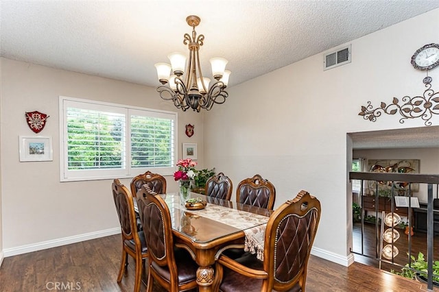 dining space featuring visible vents, baseboards, wood finished floors, and an inviting chandelier