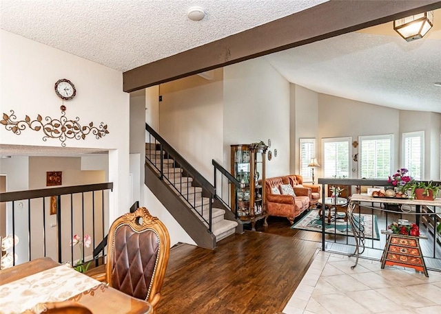 tiled dining room featuring stairs, a textured ceiling, and lofted ceiling