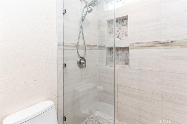 full bathroom with toilet and a shower stall