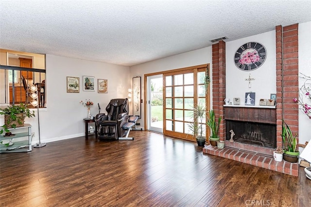 sitting room with a textured ceiling, visible vents, and wood finished floors