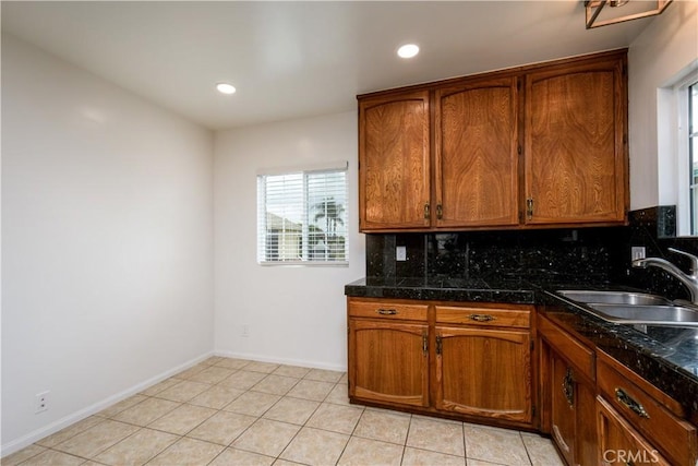 kitchen featuring recessed lighting, brown cabinetry, decorative backsplash, and a sink