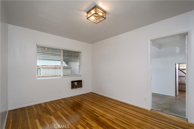 empty room with baseboards and wood finished floors