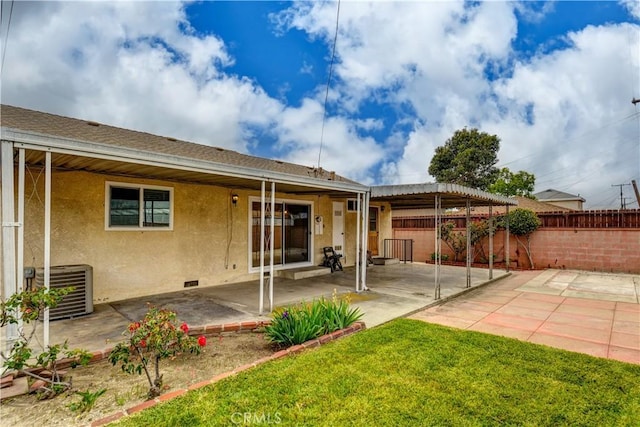 back of property with stucco siding, crawl space, a fenced backyard, central AC unit, and a patio area