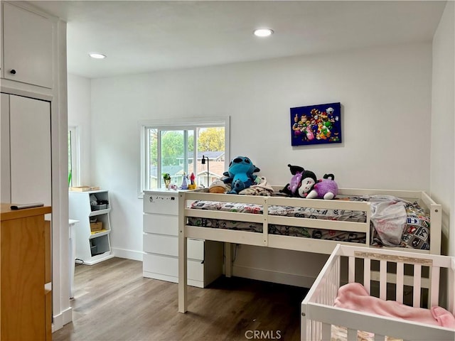 bedroom with recessed lighting and wood finished floors