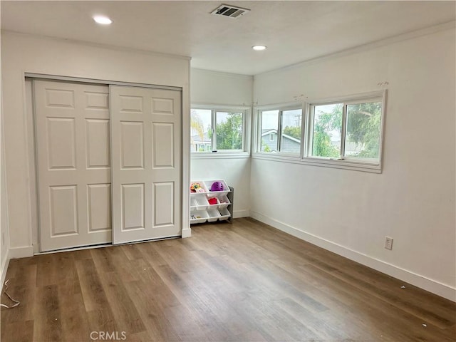 bedroom featuring baseboards, visible vents, and wood finished floors