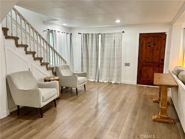 entrance foyer with baseboards, stairs, crown molding, and wood finished floors