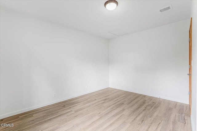unfurnished room with baseboards, light wood-style flooring, and visible vents