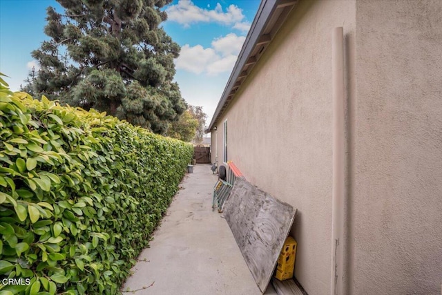 view of home's exterior with stucco siding and fence