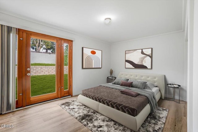 bedroom with crown molding, baseboards, wood finished floors, and access to exterior