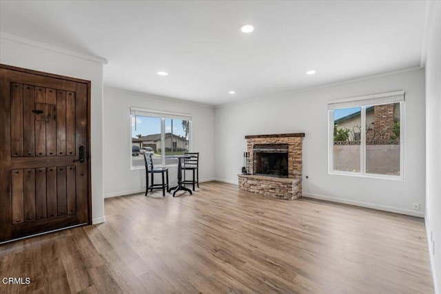 living area with wood finished floors, a fireplace, crown molding, baseboards, and recessed lighting