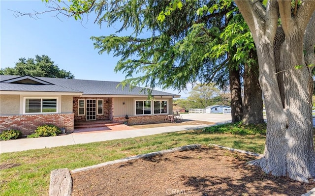 ranch-style house with a shingled roof and brick siding