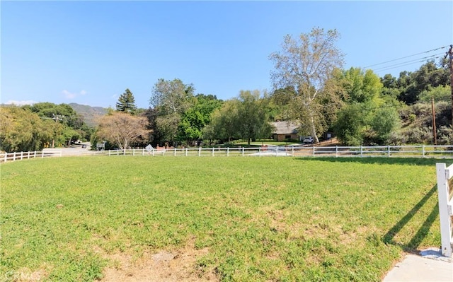 view of yard with a rural view and fence