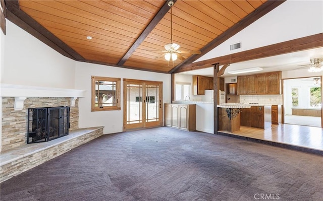 unfurnished living room featuring wooden ceiling, visible vents, dark carpet, and vaulted ceiling with beams