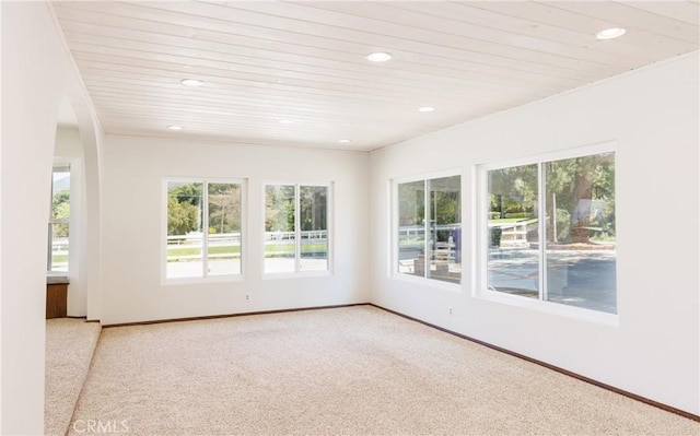 carpeted empty room with wooden ceiling, baseboards, and recessed lighting