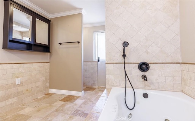bathroom with tile walls, ornamental molding, a tub with jets, and a wainscoted wall