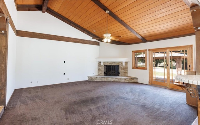 unfurnished living room featuring carpet, wooden ceiling, a stone fireplace, ceiling fan, and vaulted ceiling with beams