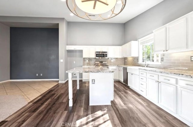 25624 Driftview Cir, Menifee, CA 92584 - kitchen featuring appliances with stainless steel finishes, white cabinetry, tasteful backsplash, a center island, and recessed lighting