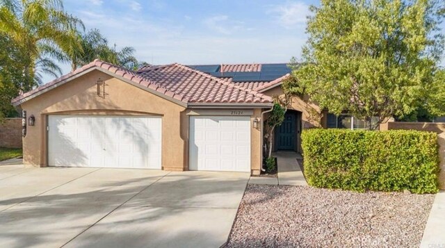 25624 Driftview Cir, Menifee, CA 92584 - mediterranean / spanish home with stucco siding, roof mounted solar panels, concrete driveway, a tile roof, and a garage