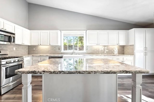 25624 Driftview Cir, Menifee, CA 92584 - kitchen with stainless steel appliances, wood finished floors, tasteful backsplash, a center island, and high vaulted ceiling
