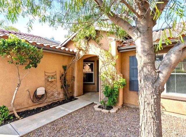 25624 Driftview Cir, Menifee, CA 92584 - doorway to property featuring stucco siding and a tile roof
