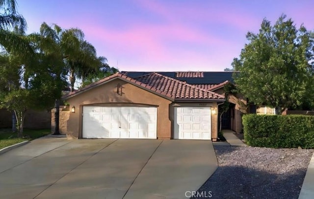 25624 Driftview Cir, Menifee, CA 92584 - mediterranean / spanish-style home with concrete driveway, a garage, stucco siding, roof mounted solar panels, and a tile roof