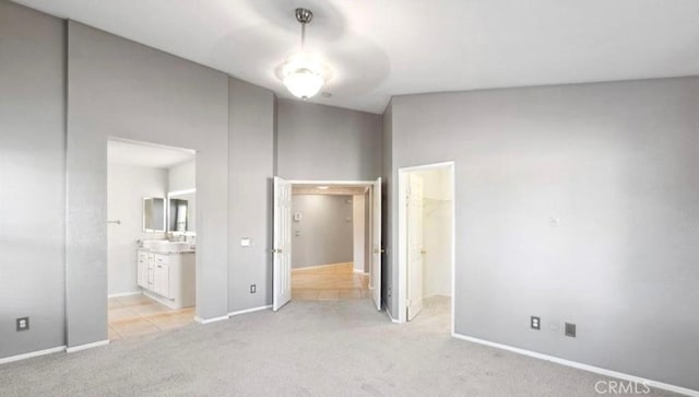 25624 Driftview Cir, Menifee, CA 92584 - unfurnished bedroom featuring light colored carpet, a walk in closet, connected bathroom, baseboards, and a closet