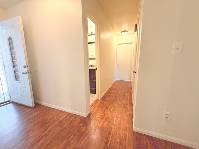 hallway with light wood finished floors and baseboards