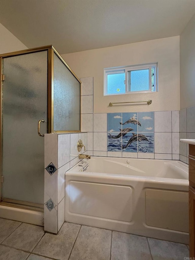 bathroom with a stall shower, tile walls, tile patterned floors, and a garden tub