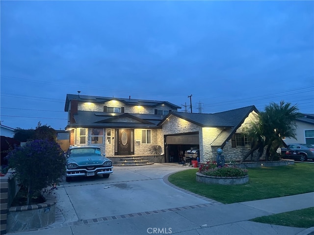 view of front of property with concrete driveway, an attached garage, a front lawn, and stone siding