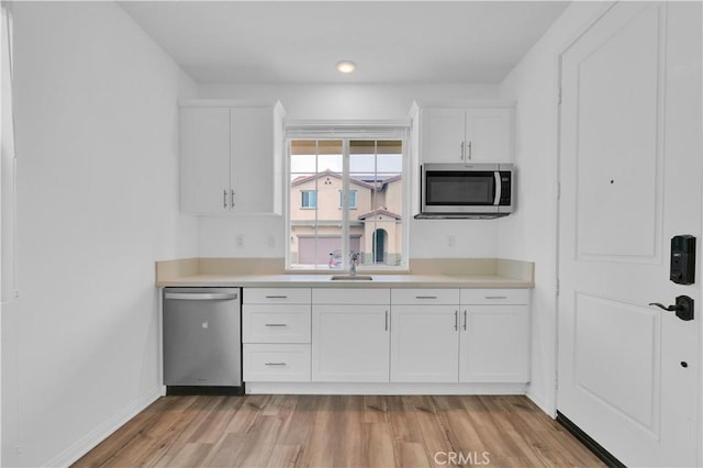 14667 Gulfstream Ln, Moreno Valley, CA 92553 - kitchen featuring stainless steel appliances, white cabinetry, light countertops, and light wood-style floors