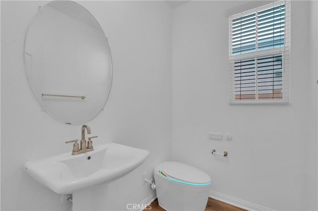 14667 Gulfstream Ln, Moreno Valley, CA 92553 - half bathroom featuring a sink, toilet, baseboards, and wood finished floors