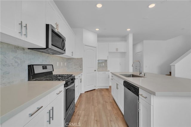 14667 Gulfstream Ln, Moreno Valley, CA 92553 - kitchen featuring a sink, light wood-type flooring, white cabinetry, light countertops, and appliances with stainless steel finishes
