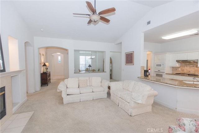 1490 N Dewitt Ave, Clovis, CA 93619 - living area with ceiling fan with notable chandelier, visible vents, arched walkways, light colored carpet, and vaulted ceiling
